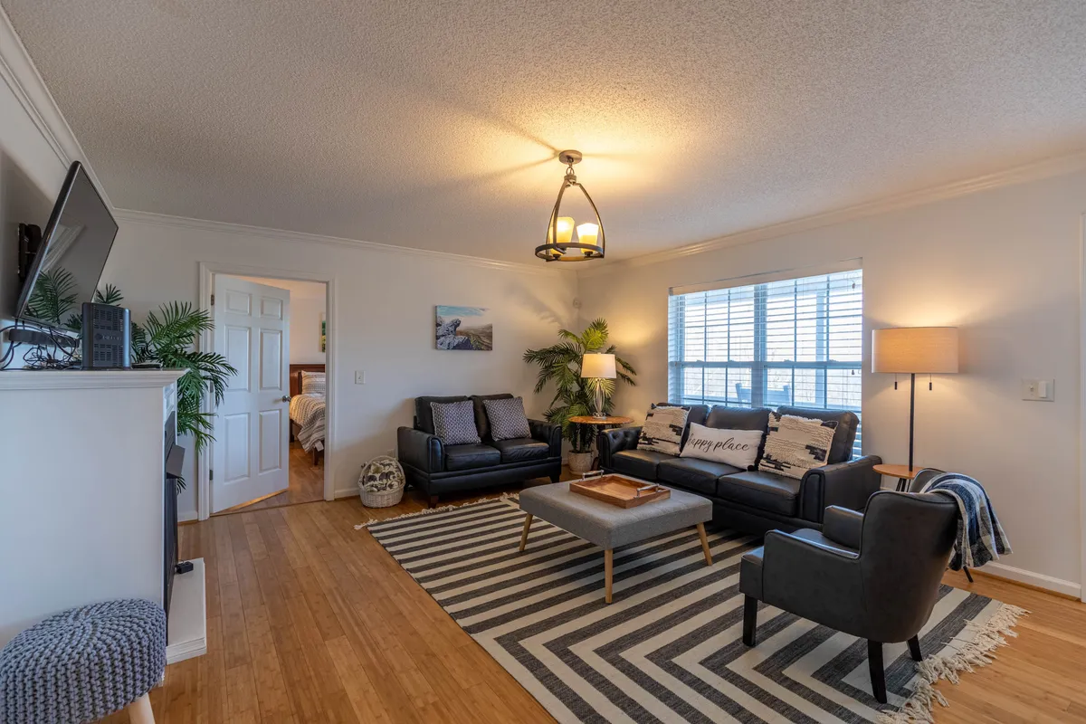 The main living area, featuring a comfortable sofa, coffee table, and inviting accents, bathed in natural light. The space is arranged for socializing, group games, or relaxing together after a day of adventure.