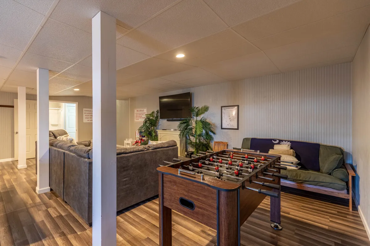 This image highlights a fun, casual space featuring a foosball table, sofas, a television, and a potted plant. The setup encourages group games, relaxation, and family bonding over lively activities.